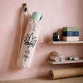 Yoga mat tote bag with lotus print hanging on a blush pink wall