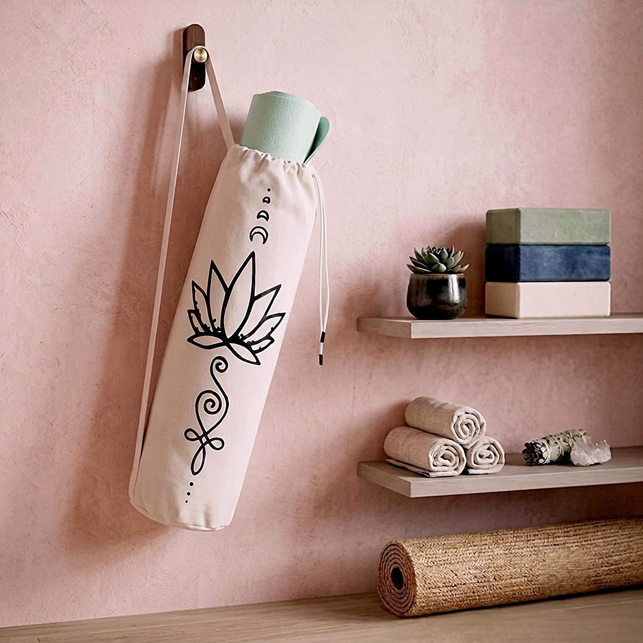 Yoga mat tote bag with lotus print hanging on a blush pink wall